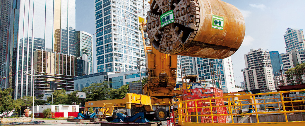 Tunnel boring machine hanging from a crane on a utility construction site
